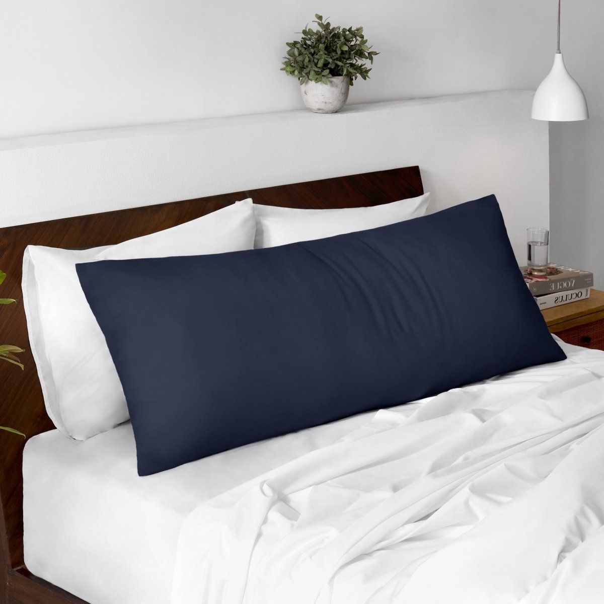 Body pillow on a bed with a wooden headboard and minimal decor.