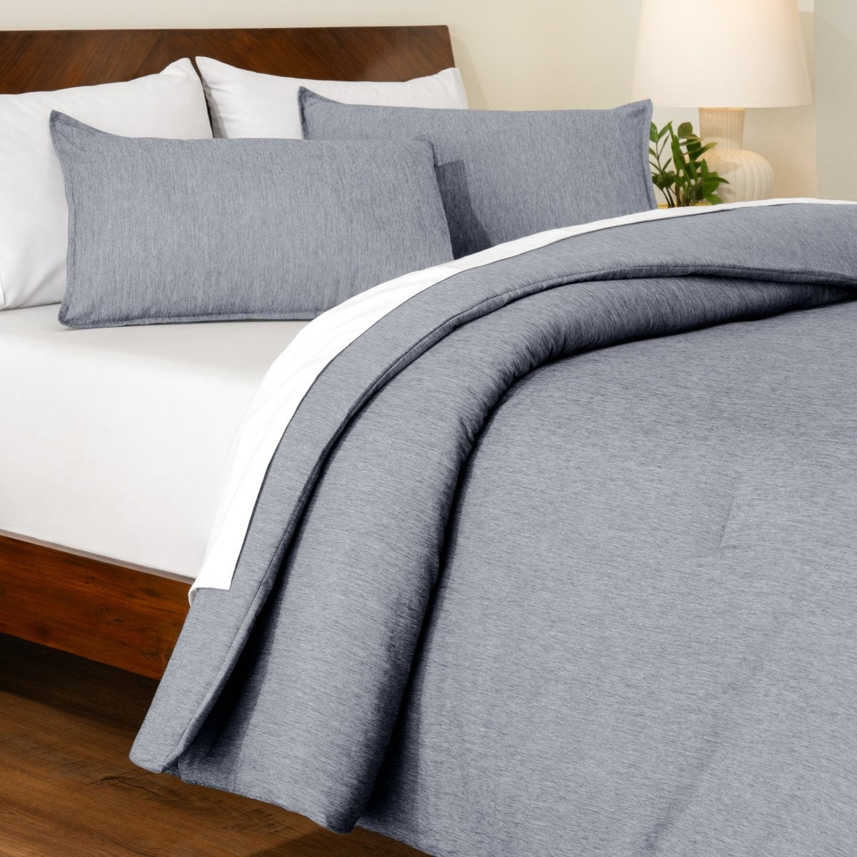 Track stitch comforter on a bed with white pillows and a wooden headboard.