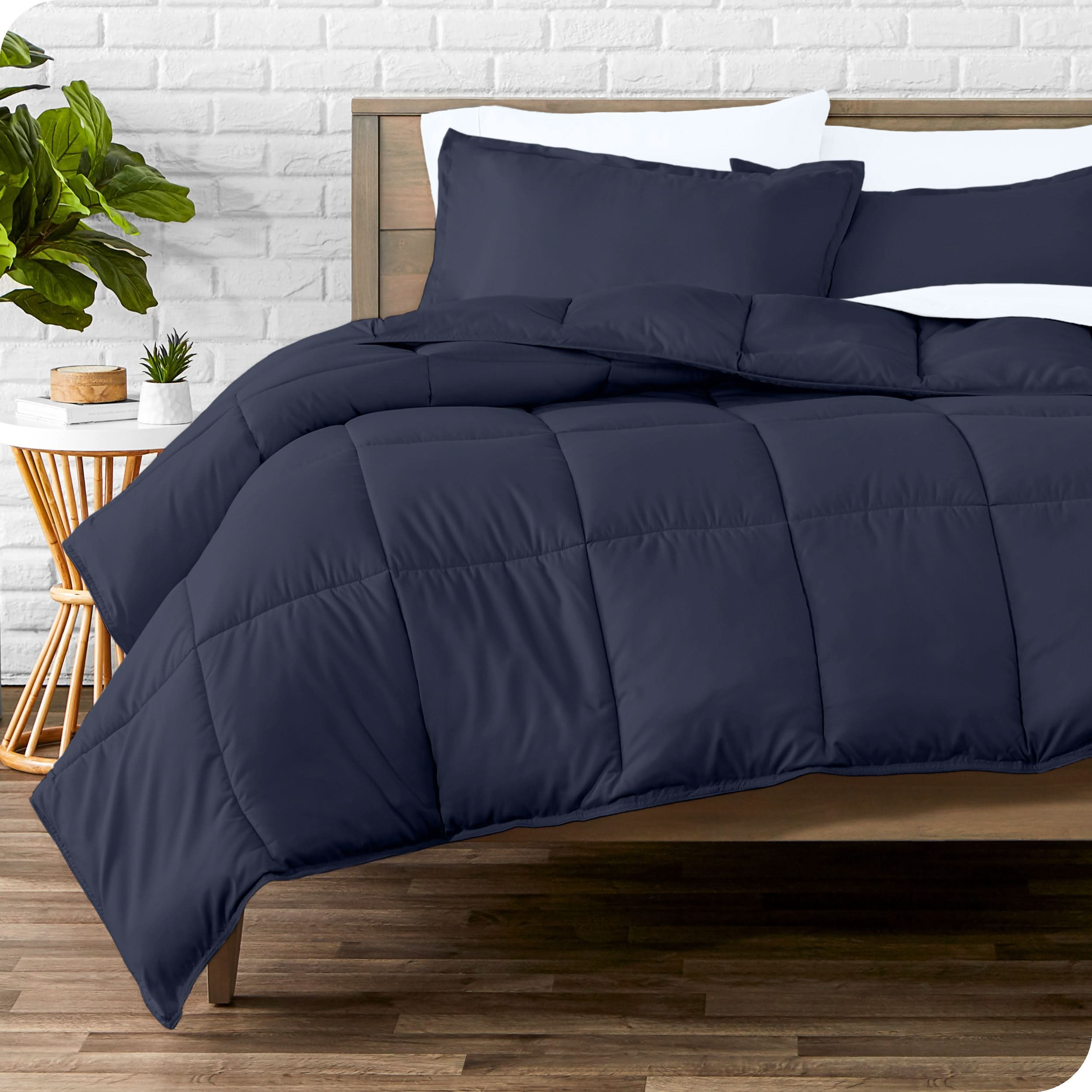 A modern bed with a down alternative comforter set on it