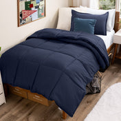 Bed with comforter and pillows in a dorm room