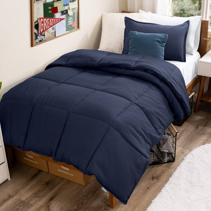 Bed with comforter and pillows in a dorm room