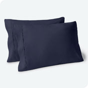 Two pillows on a white background with blue pillowcases on them