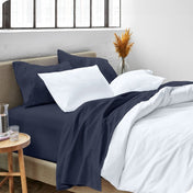 A side view of a bed made with microfiber sheets and a white duvet cover