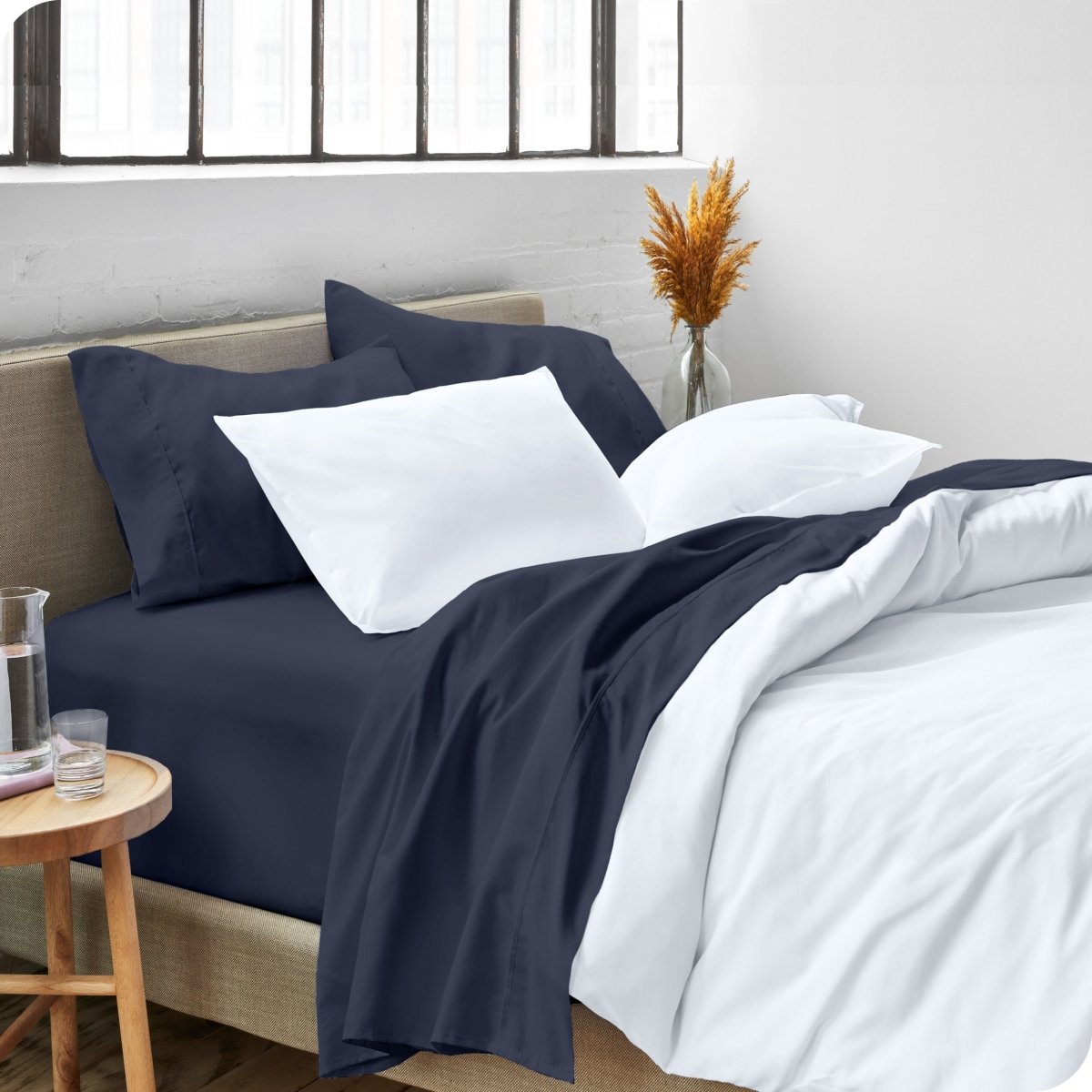A side view of a bed made with microfiber sheets and a white duvet cover