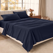 Bed sheets on a neatly made bed in a bright bedroom with large windows.