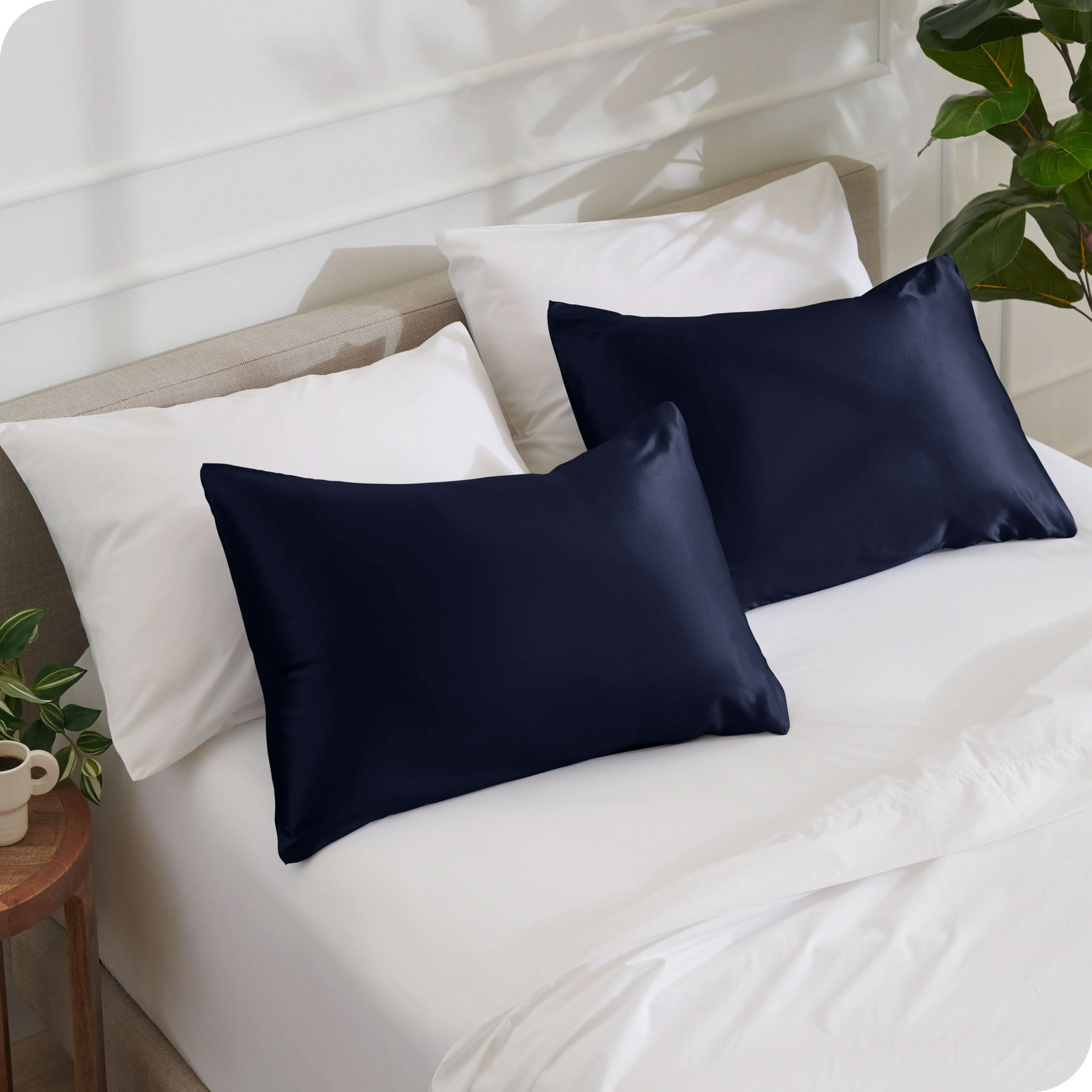 2 satin pillowcases on pillows set on a bed