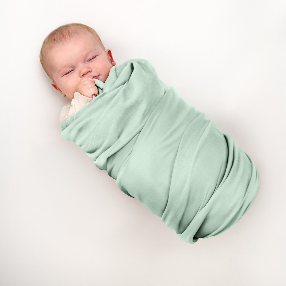 A baby wrapped in a flannel receiving blanket