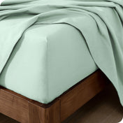 Close up of the corner of a mattress with a flannel fitted sheet and flat sheet on it