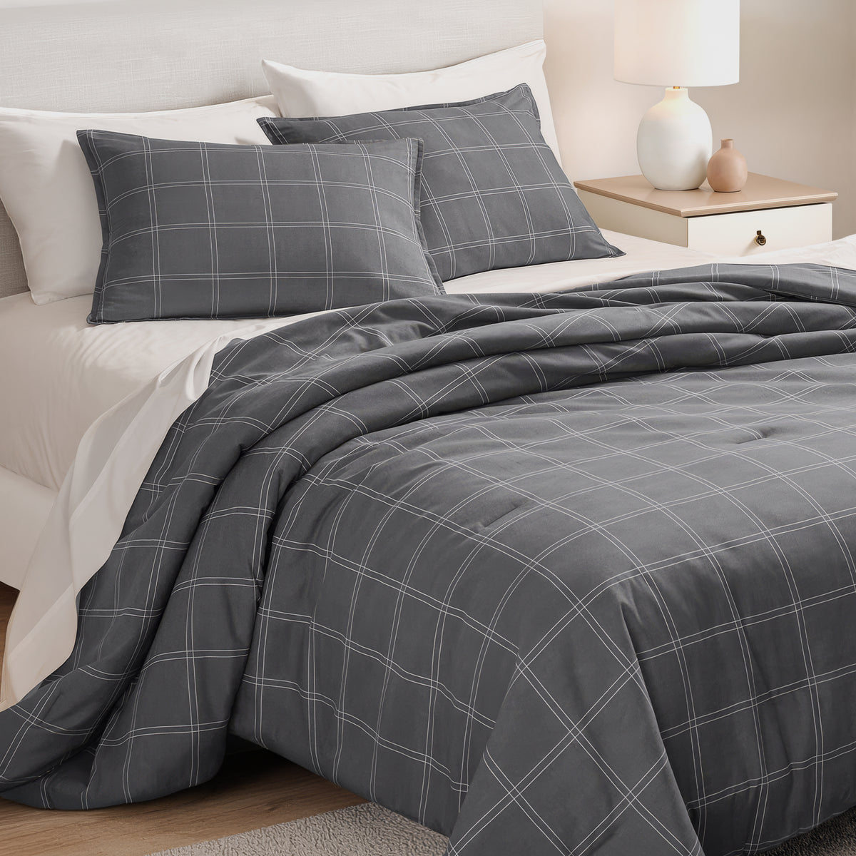 Track stitch comforter on a bed with white pillows and a wooden headboard.