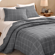 Modern plaid comforter set on a bed with white sheets