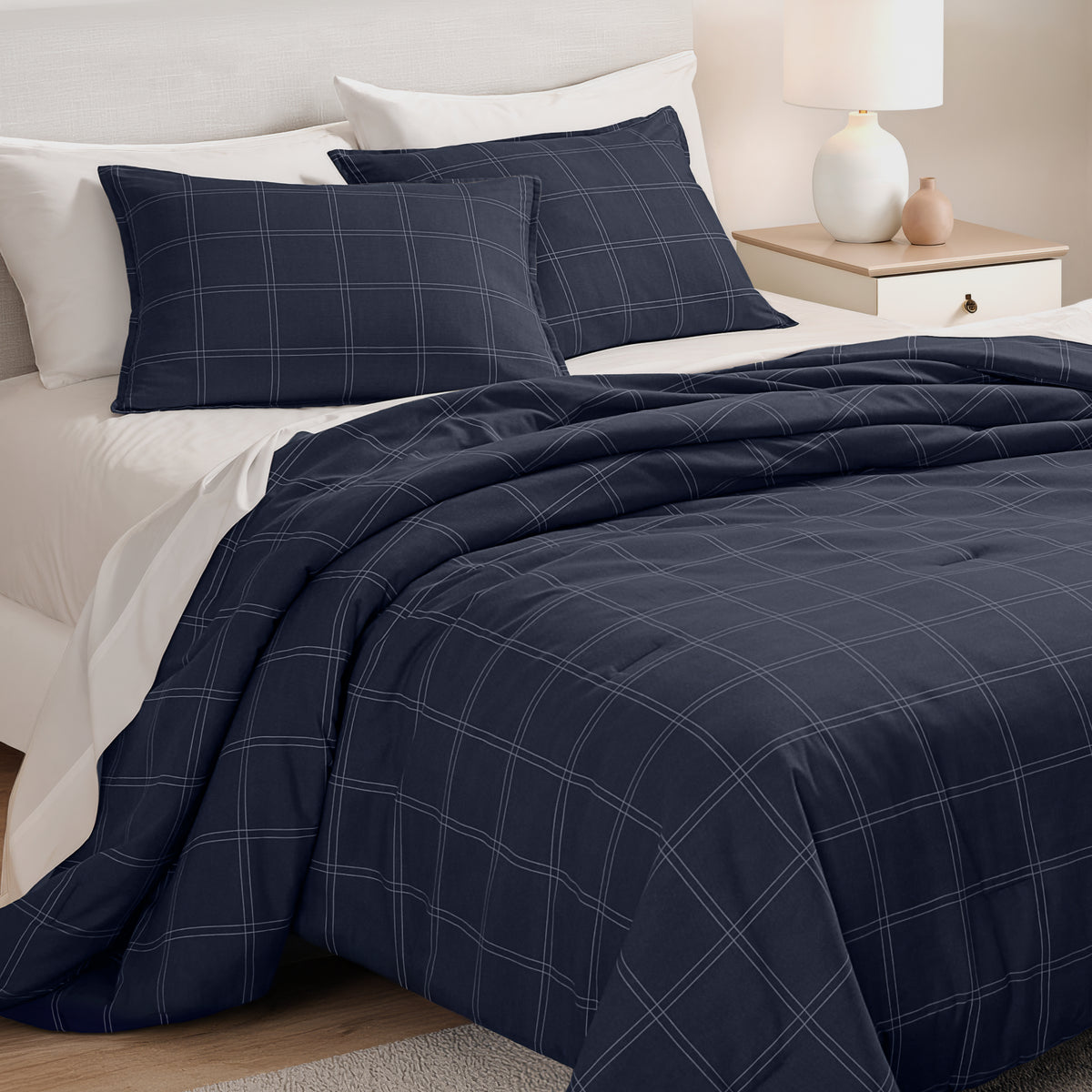 Track stitch comforter on a bed with white pillows and a wooden headboard.