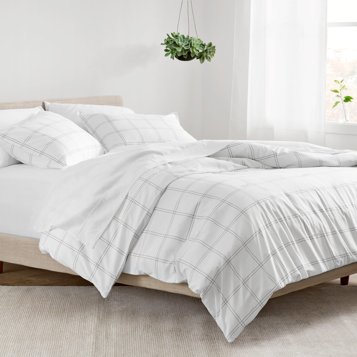 Track stitch comforter on a bed with white pillows and a wooden headboard.