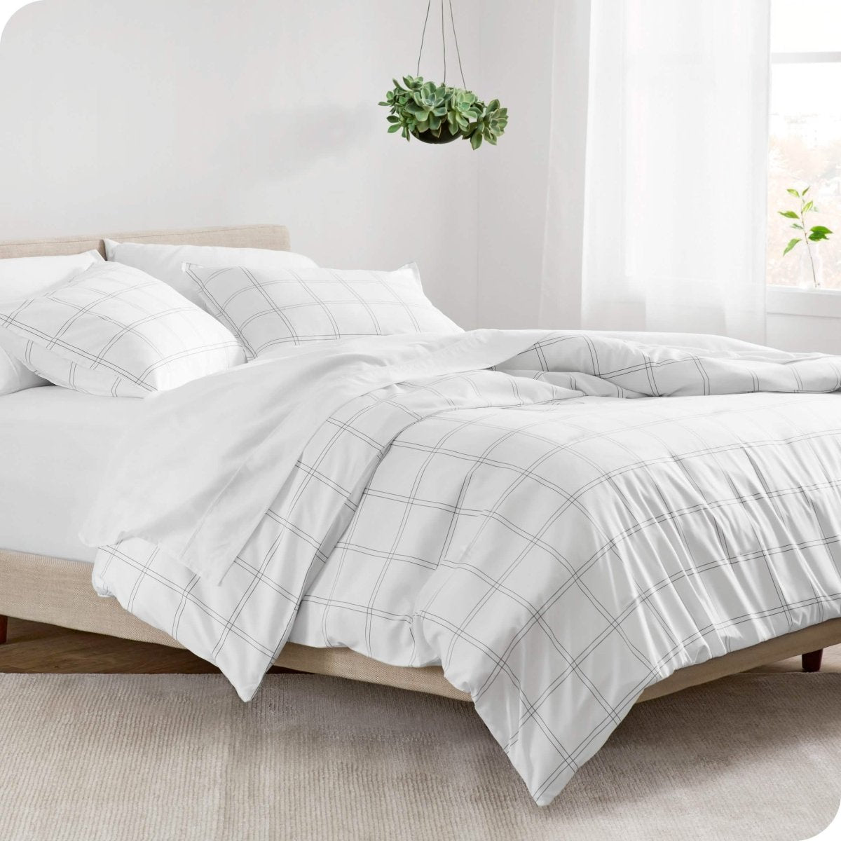 Modern plaid comforter set on a bed with white sheets