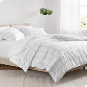 Modern plaid comforter set on a bed with white sheets
