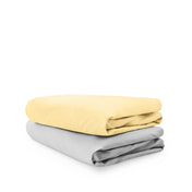 Stack of folded crib sheets on a white background