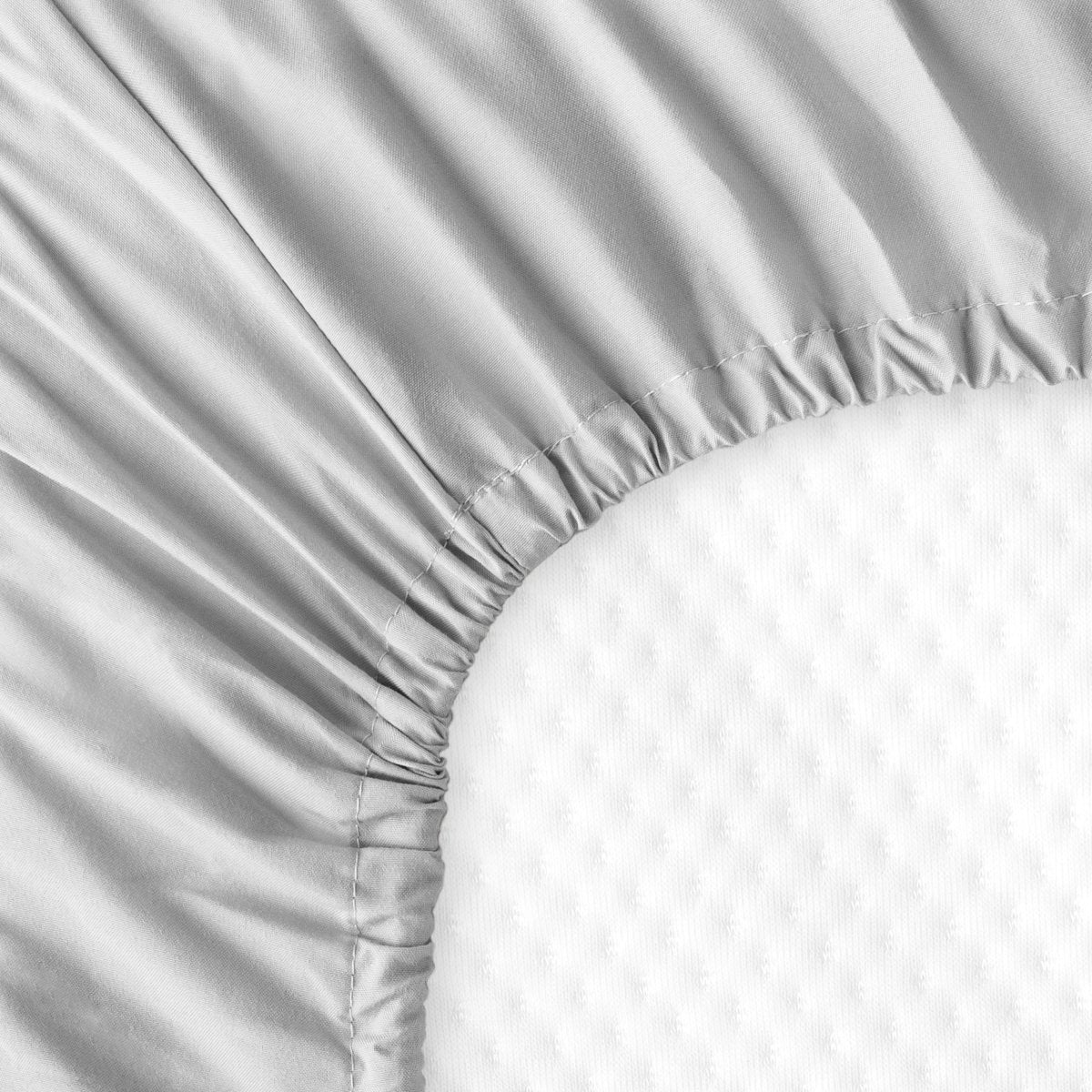 The back of a crib mattress with a fitted sheet on it