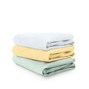 Stack of folded crib sheets on a white background