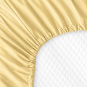 The back of a crib mattress with a fitted sheet on it