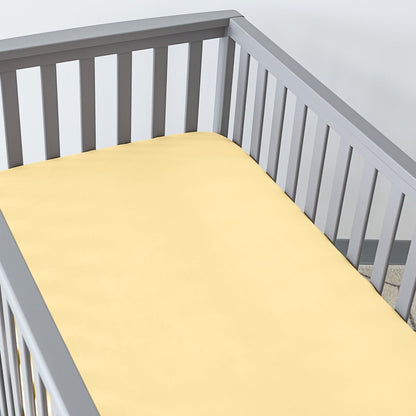 Gray crib with a fitted sheet on the mattress