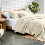 Relaxing room scene showing a natural color linen duvet cover set laid out over the bed