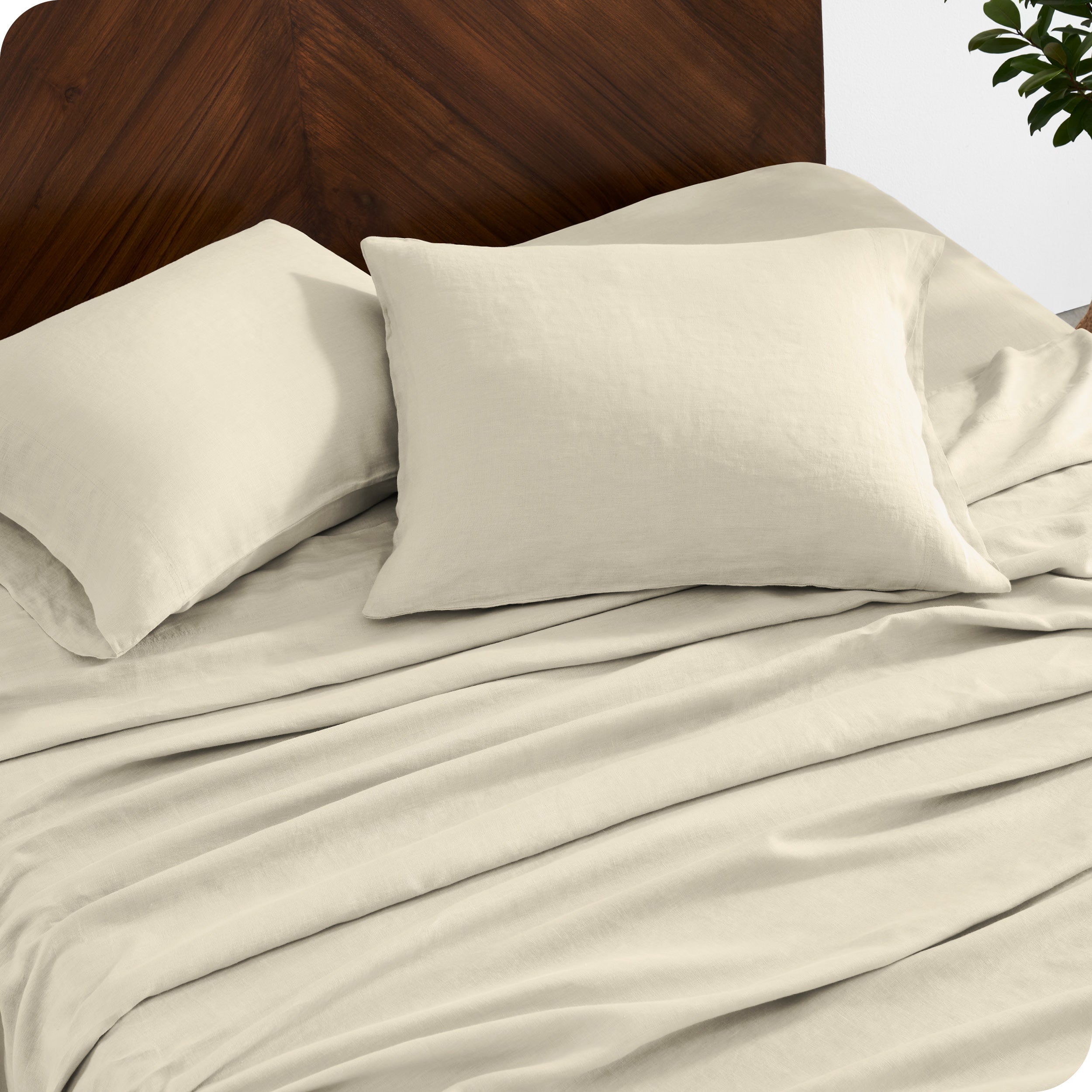 Close up of linen sheet set on a mattress with pillows inside the pillowcases