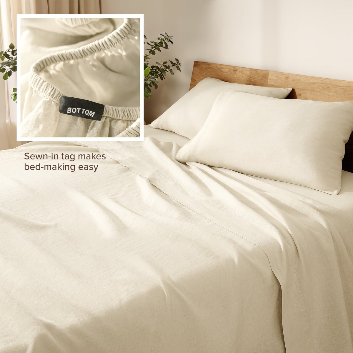 Linen bed sheets and pillowcases on a wooden bed with a plant in the background