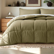 Comforter on a bed in a bedroom setting with a wooden nightstand and decorative items.