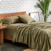 Bed with microfiber sheets against a white brick wall