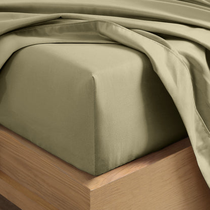 Close up of the corner of a mattress with a fitted sheet and flat sheet on it