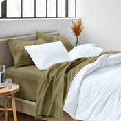 A side view of a bed made with microfiber sheets and a white duvet cover