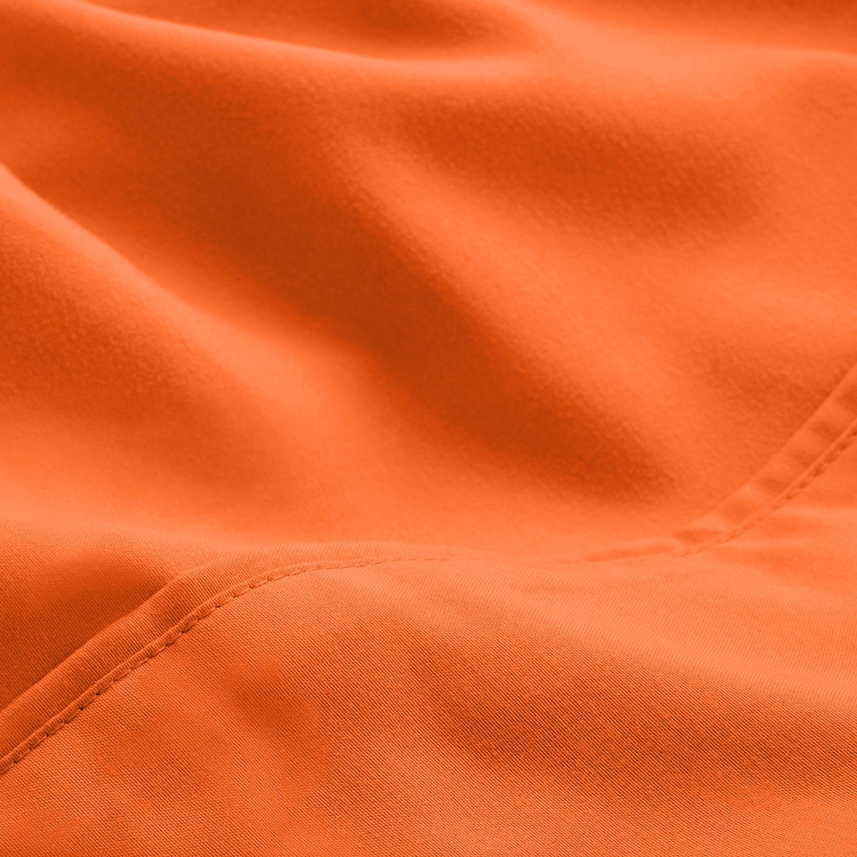 A close-up of microfiber fabric with soft folds and a visible stitched seam.