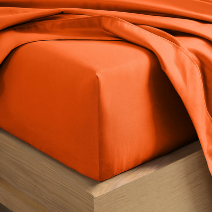 A close-up of a fitted sheet covering the corner of a bed frame, with matching top sheet draped over it.