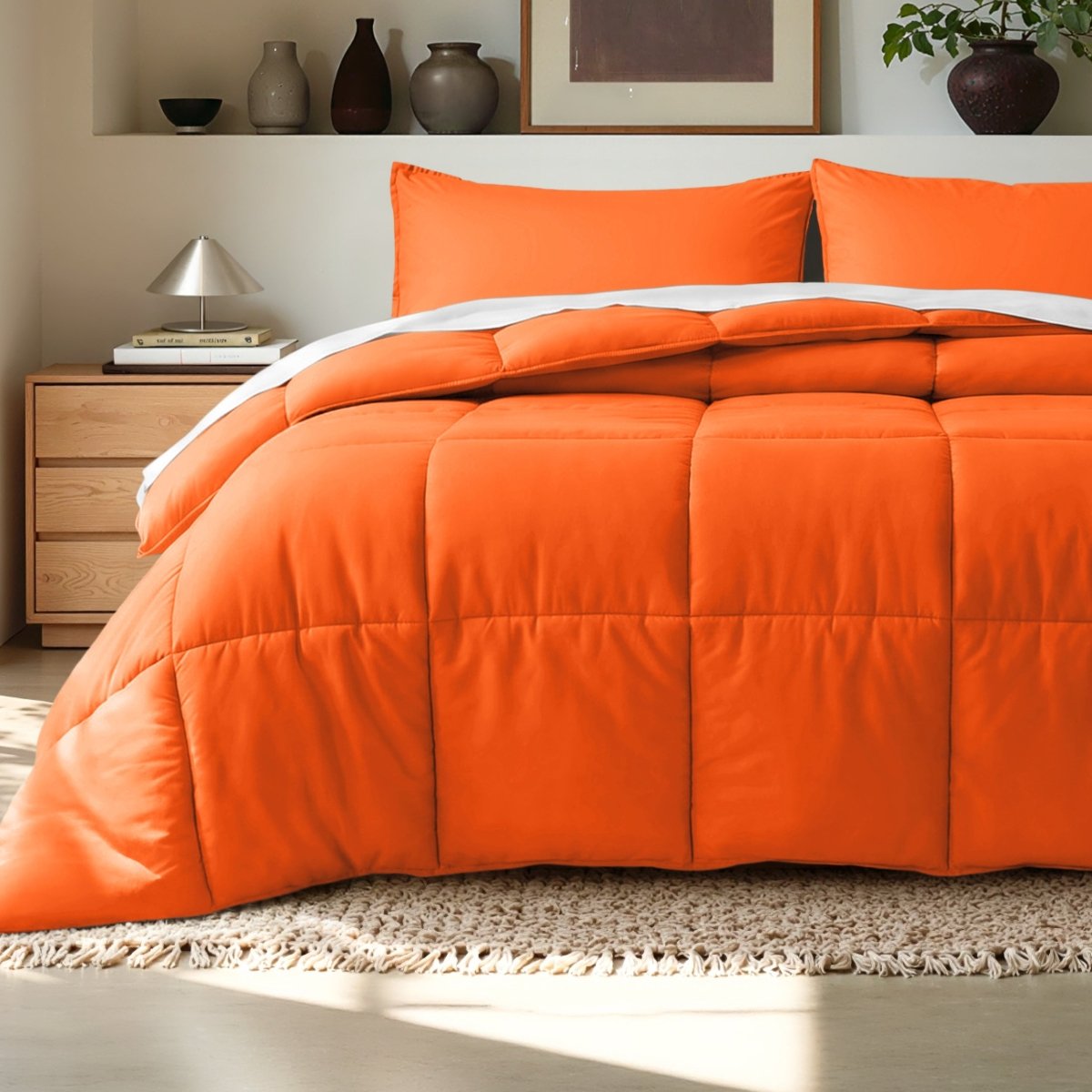 Comforter on a bed in a bedroom setting with a wooden nightstand and decorative items.