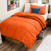 Bed with comforter and pillows in a dorm room