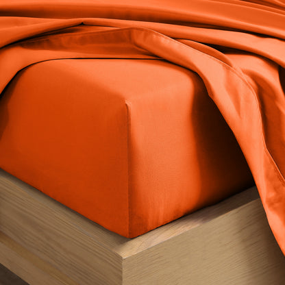 Close up of the corner of a mattress with a fitted sheet and flat sheet on it