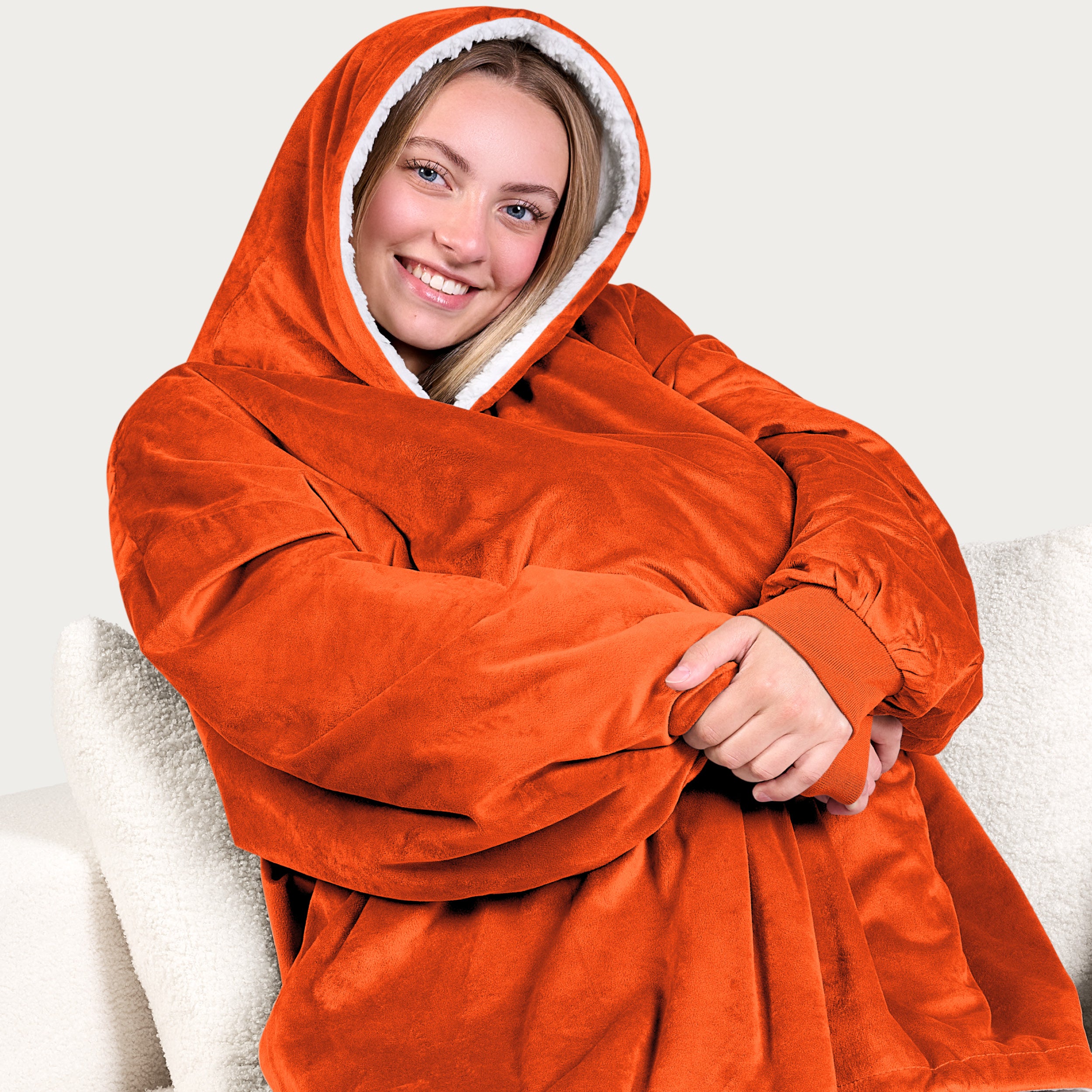An adult with a hooded wearable blanket on