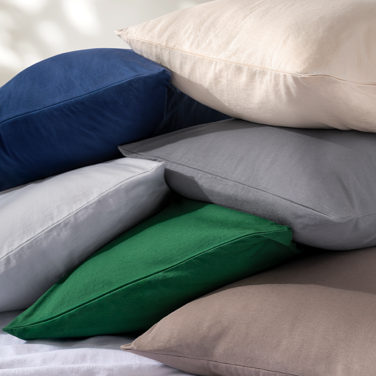 Stack of multicolored pillows on a neutral background