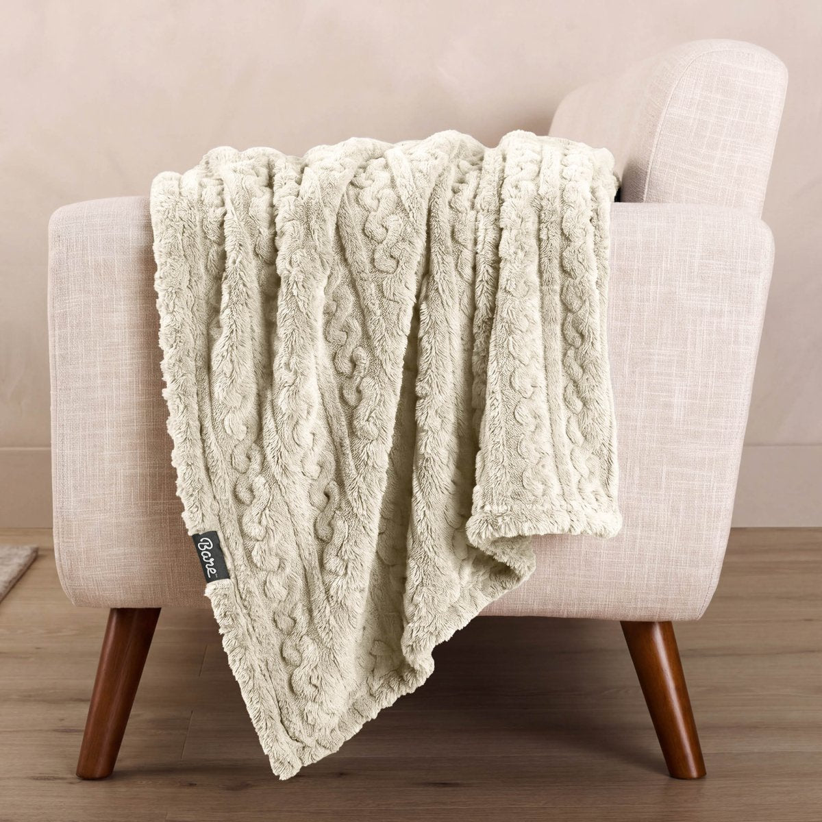 Cable knit blanket draped over the arm of a chair