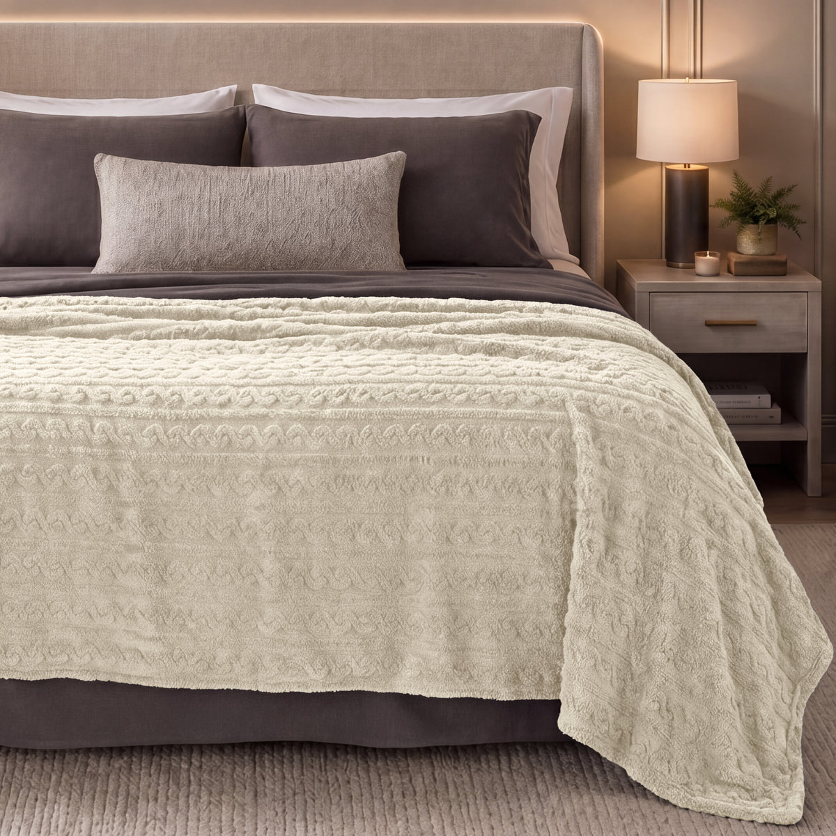 Bed with oyster textured blanket in a bedroom setting.