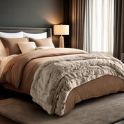 Neatly made bed and a textured throw blanket  over the end of the bed.