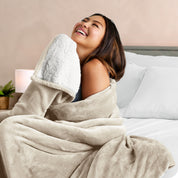 A woman smiling while wrapped in a sherpa blanket