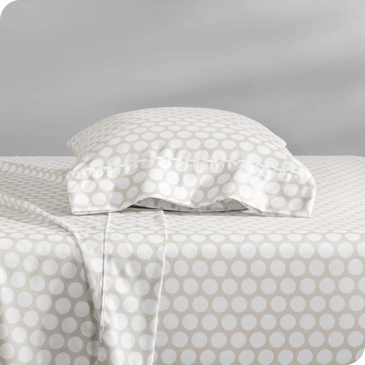 Two pillows with pillowcases on them stacked on a bed