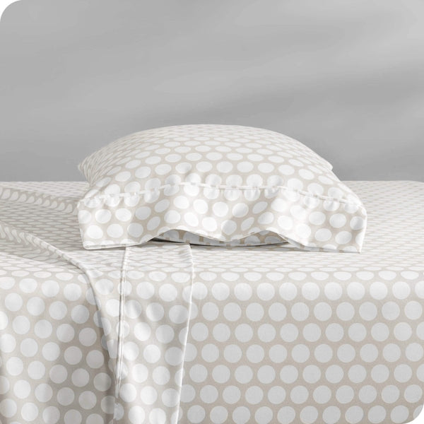 Two pillows with pillowcases on them stacked on a bed