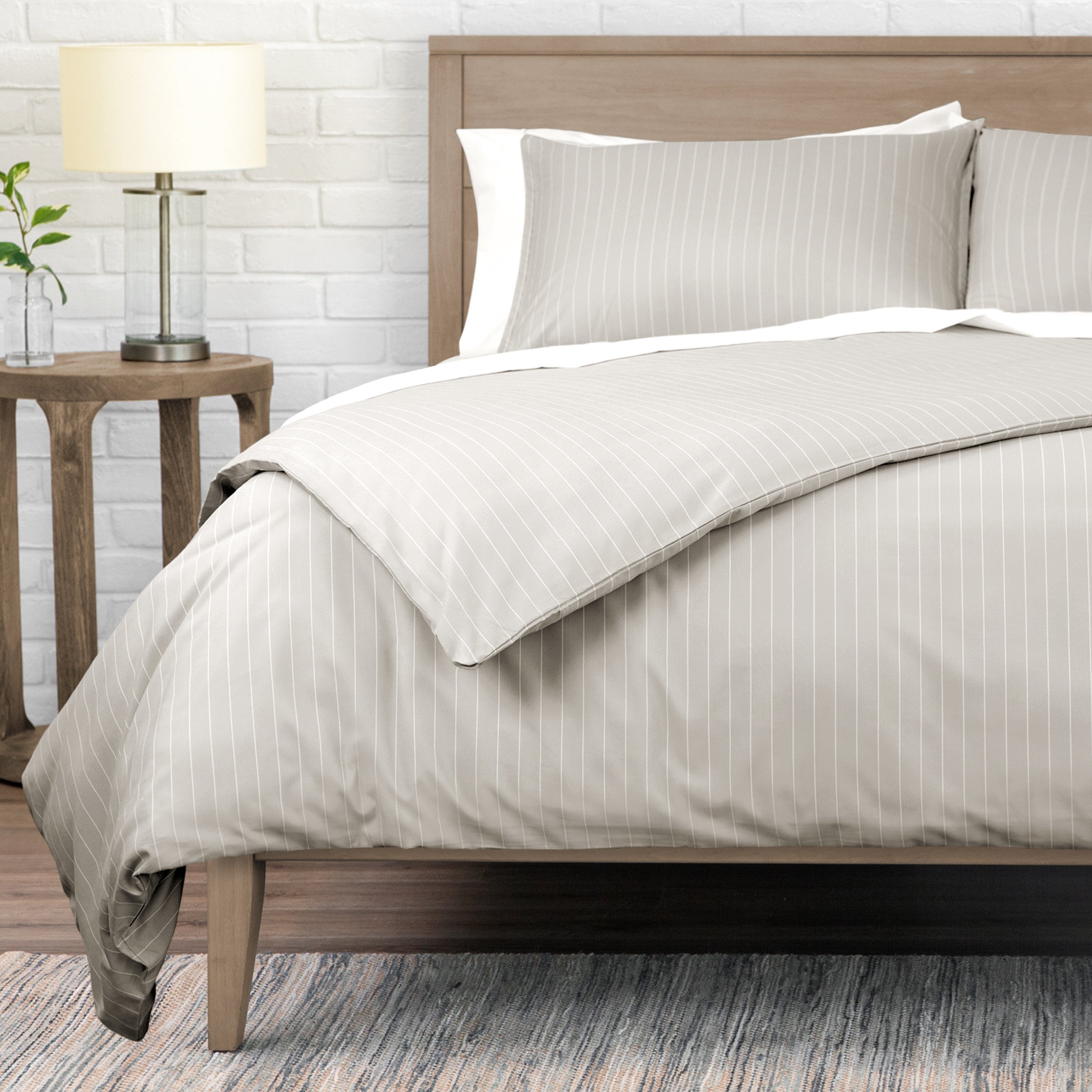 Neatly made bed with striped bedding in a bedroom setting.