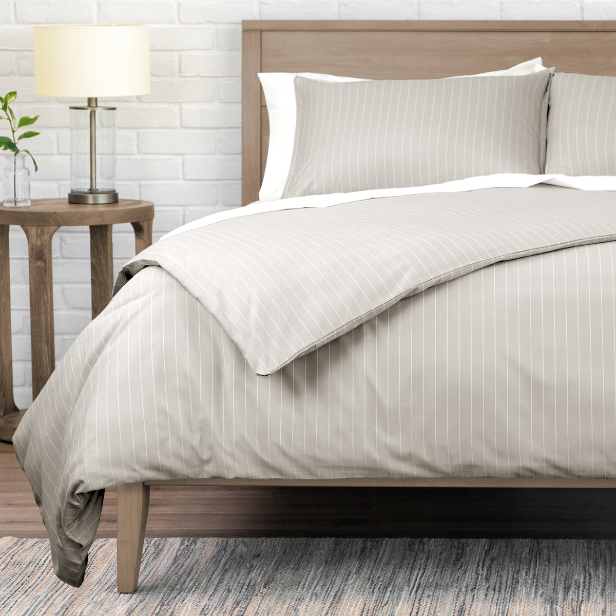 Neatly made bed with striped bedding in a bedroom setting.