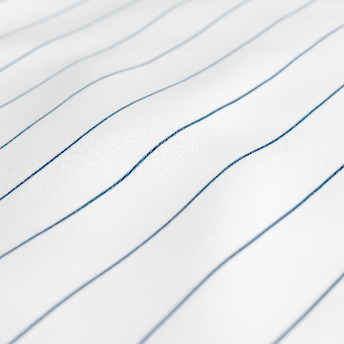 A close-up of white fabric with thin blue pinstripes
