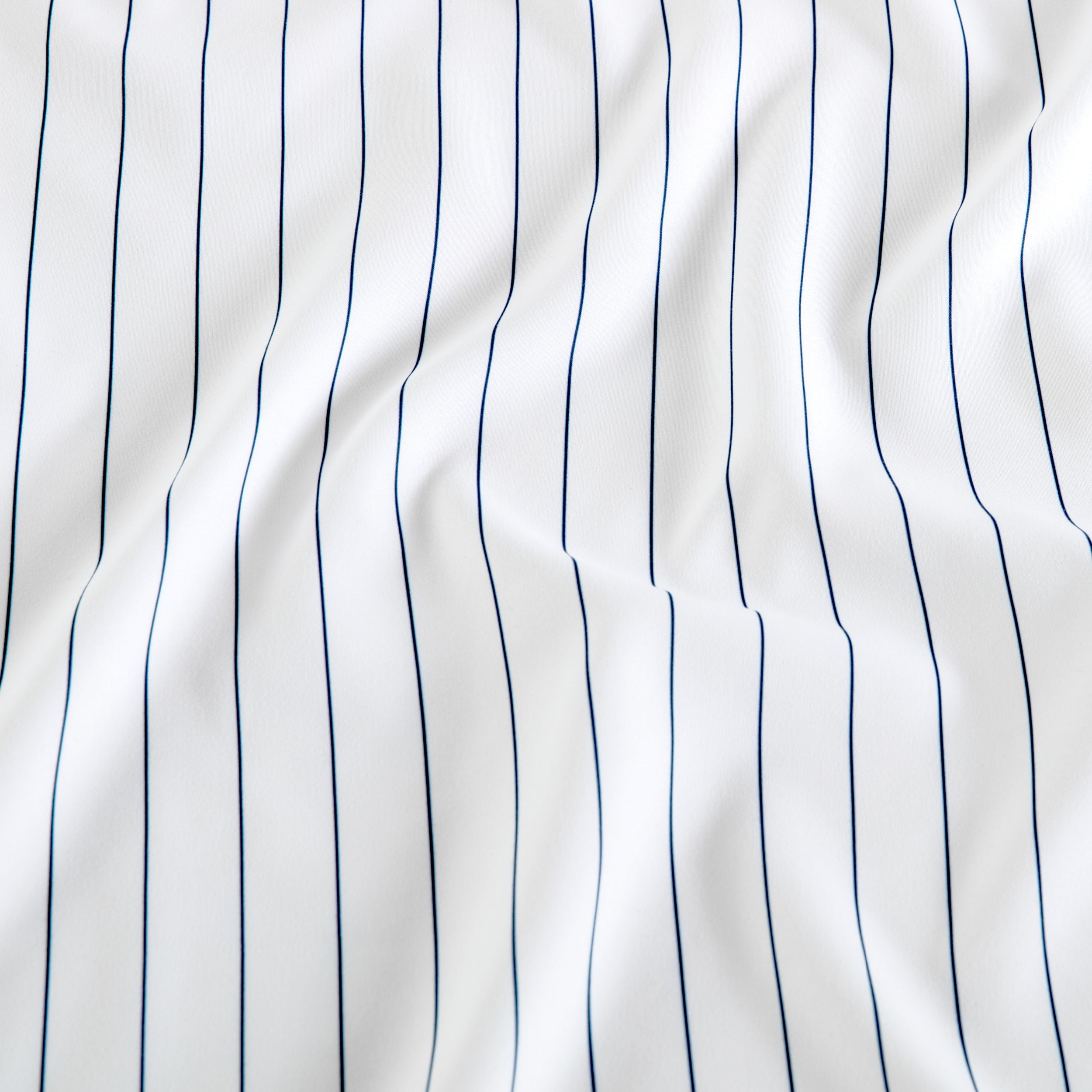 White fabric with thin vertical navy blue pinstripes
