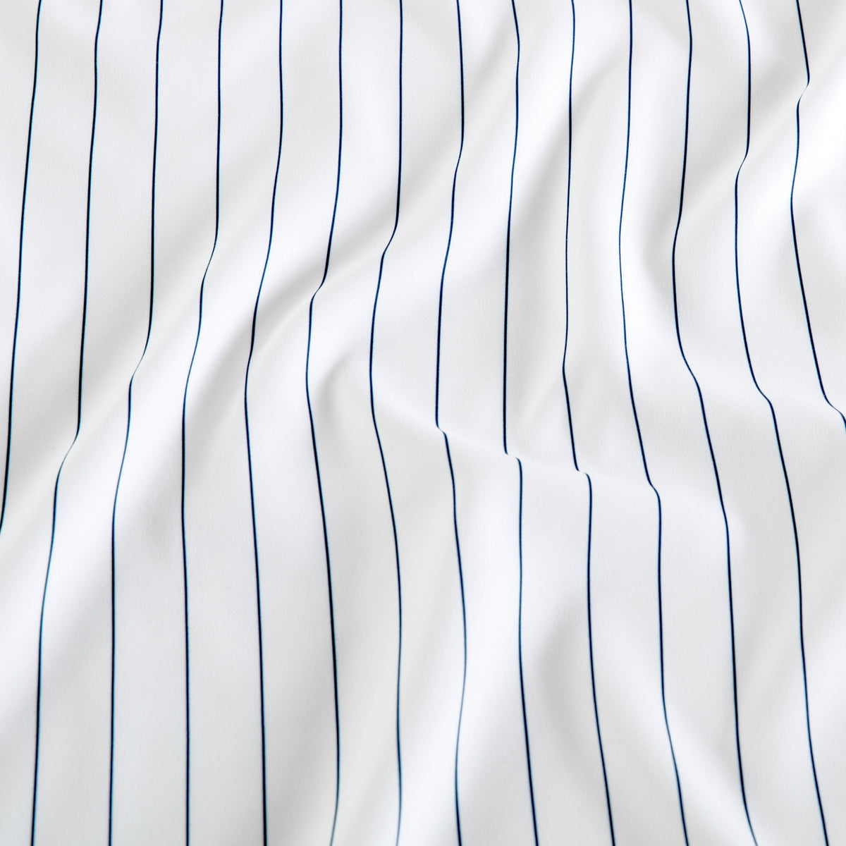 White fabric with thin vertical navy blue pinstripes