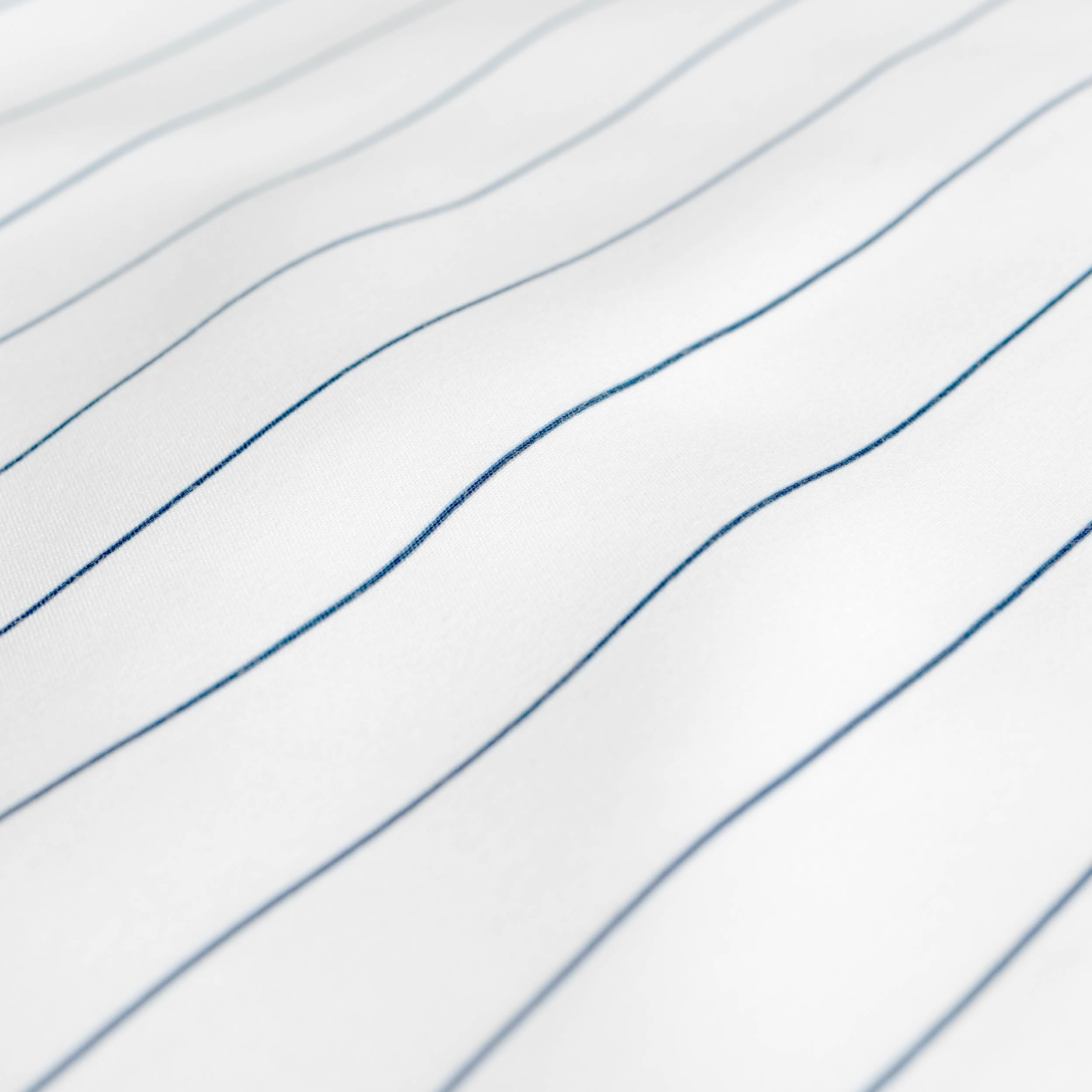 A close-up of white fabric with thin, blue pinstripes