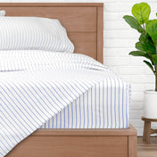 A bed made with pinstripe sheets